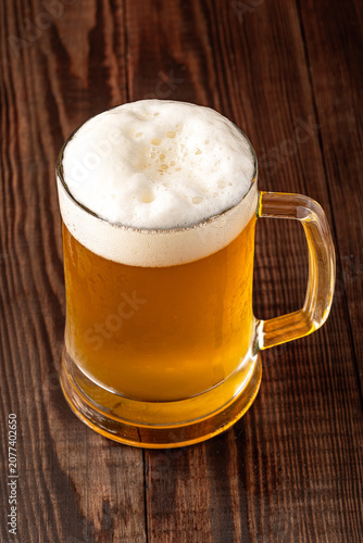 Glass of cold beer on wooden background