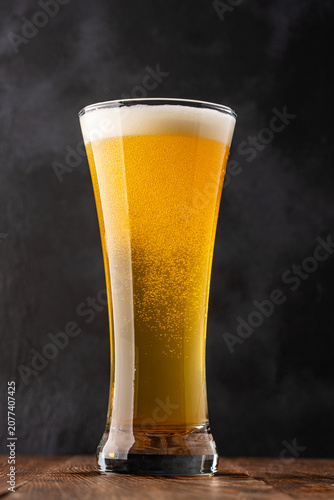 Glass of cold beer on wooden background