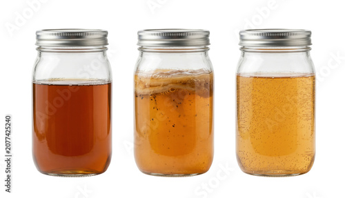 Foto Glass mason jars showing kombucha tea fermentation process stages