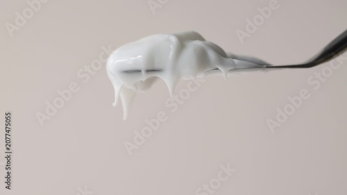 Beautiful white milky texture of cosmetic cream, lotion, shampoo close-up, beige background.