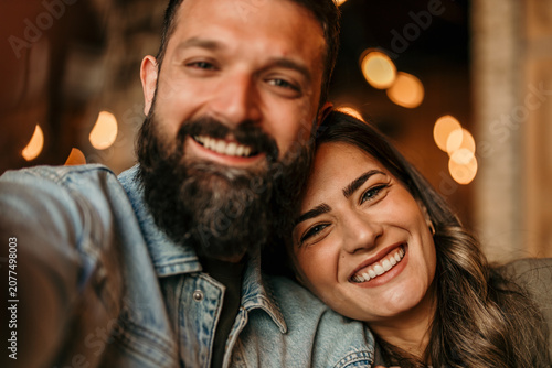 Bild auf Leinwand Happy couple enjoying a self-portrait moment indoors