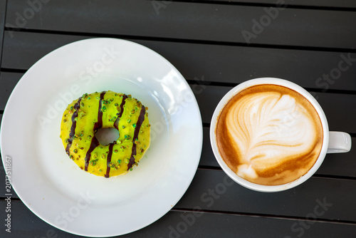 Foto A green pistachio glazed donut with chocolate stripes sits on a white plate next