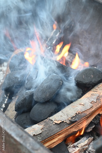 Bild auf Leinwand Close-up of glowing barbecue briquettes with burning embers and soft smoke