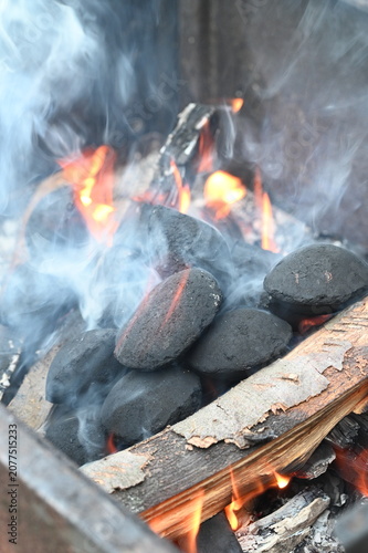 Obraz na płótnie Close-up of glowing barbecue briquettes with burning embers and soft smoke
