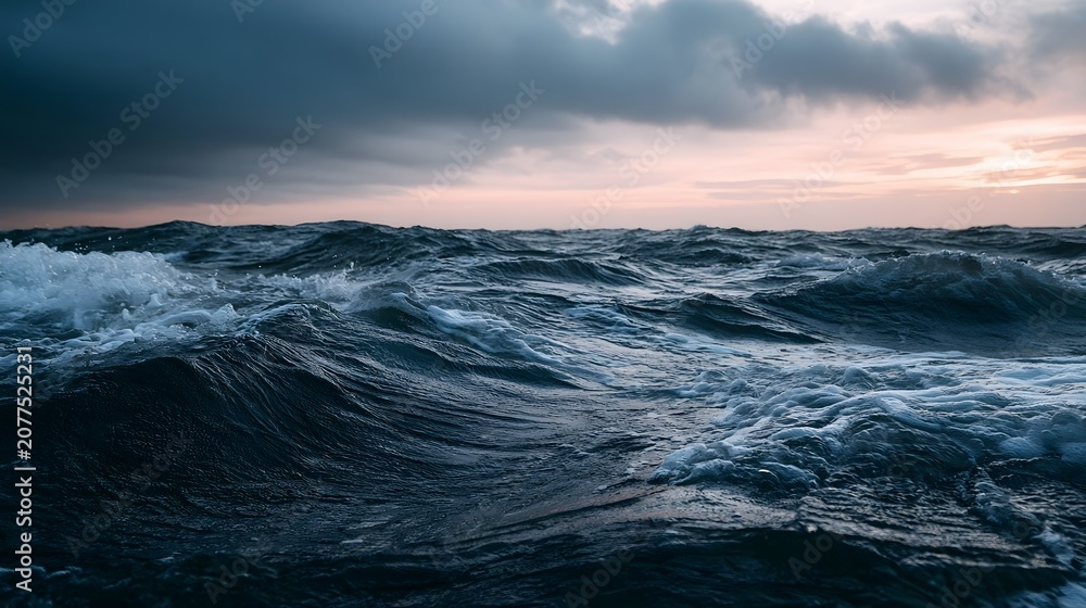 Obraz premium A dramatic seascape captures powerful rolling waves under a moody twilight sky evoking a sense of awe and wonder
