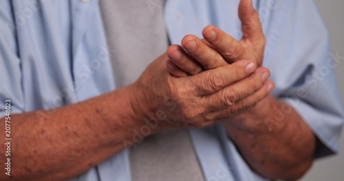 Close-up of a senior adult holding a painful hand due to arthritis, joint inflammation, or chronic hand pain. Concept of aging, musculoskeletal disorders, healthcare, pain management, elderly wellness