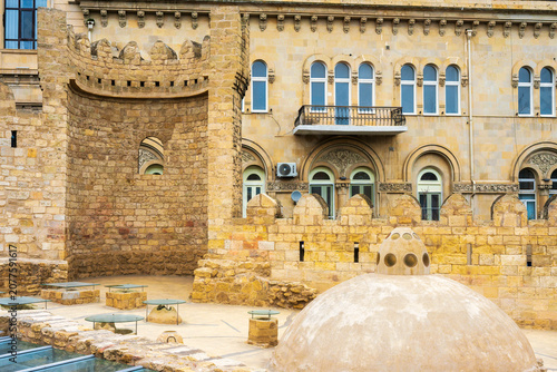 Medieval fortress walls and tower of Icheri Sheher with the dome of Yeraltı Hamam in the foreground, Baku, Azerbaijan.