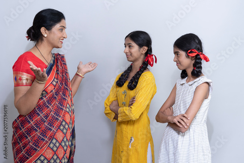 Tableau sur toile A mother is in delight and feeling proud moments with both of her daughters as they are obeying her teachings, good manners feeling happy and proud showing a lovely mother-daughter bond