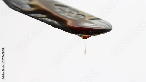 Beautiful brown serum lotion flowing close-up front view.