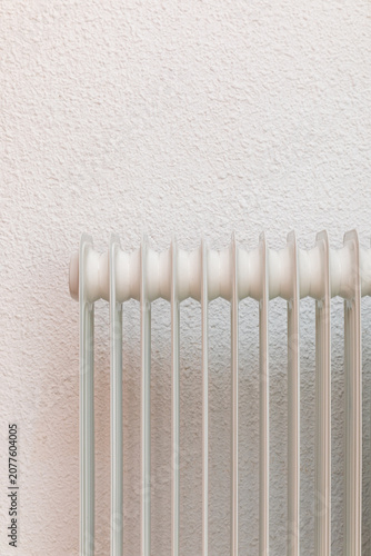 Home radiator in front of textured wallpaper interior wall