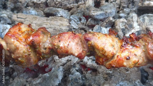 Juicy pieces of marinated meat on a skewer over hot embers in close up