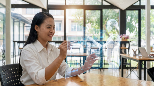 Professional woman communicating with a holographic AI assistant in a modern office, illustrating human and artificial intelligence collaboration.