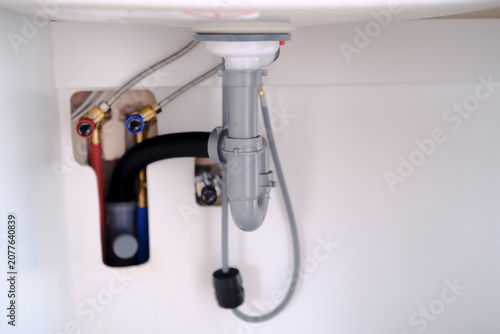 Canvastavla Under sink plumbing with water supply lines and drain pipe