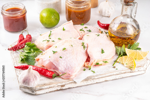 Fresh raw organic chicken thighs, with spices and condiments