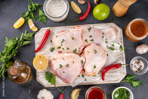 Fresh raw organic chicken thighs, with spices and condiments