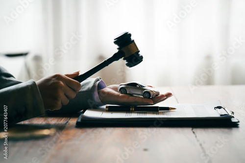 Фотография Judge's gavel above a model car, symbolizing vehicle auctions, legal disputes, insurance claims, and automotive law