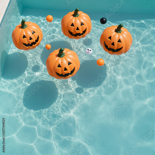 floating jack-o'-lanterns in a sunny pool during halloween providing a whimsical festive atmosphere