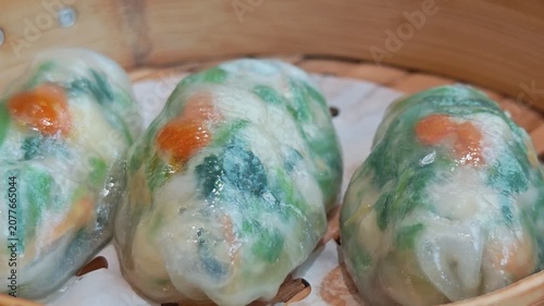 4K A video clip captures the gentle motion of freshly steamed dimsums in a bamboo steamer