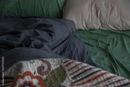 Bild auf Leinwand A bed with black, green, and beige bedding