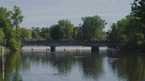 Wide shot of a small bridge and dam on a sunny day. 