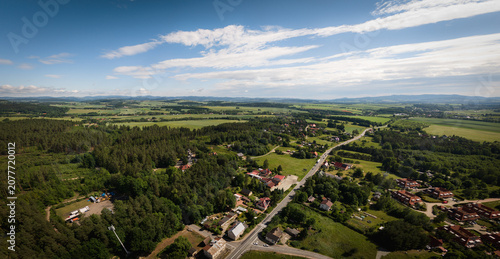 Suburban view near Polanica-Zdrój, located in the Kłodzko Valley, with fields, forests, and the Sudety Mountains in the background.