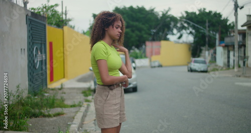 Konstfotografi Teenager of African descent standing on a quiet street with arms crossed, displa