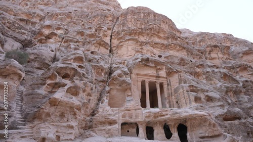 A view of the ancient rock-cut architecture and sandstone caves at the Little Petra archaeological site in Jordan.