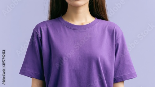 Young Woman in Purple T-shirt: A minimalist portrait of a young woman wearing a vibrant purple t-shirt, showcasing simple fashion and a clean aesthetic against a matching pastel color backdrop