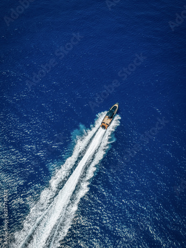 defaultAerial overhead view of a modern luxury RIB twin outboard motorboat crossing the blue ocean with high speed