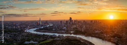 Wide, panoramic landscape view of the cityscape of London, United Kingdom, during a golden summer sunset