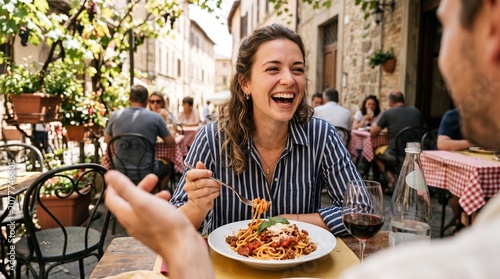 Happy woman enjoying pasta dish at outdoor cafe.