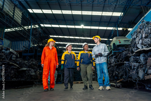 Diverse people team of industrial workers meeting and discussion in used car engines warehouse, automotive repair industry teamwork with engineers and technicians in maintenance and recycling factory.