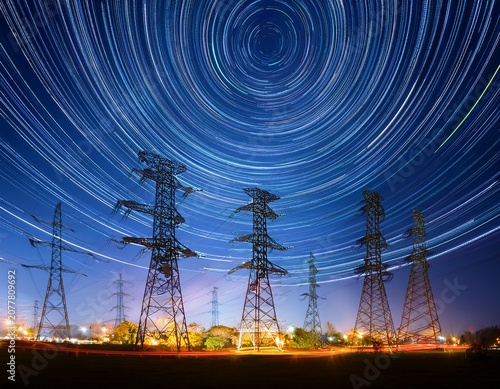sustainable data center power electric towers illuminated against a night sky with light trails representing energy flow