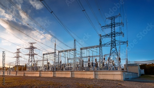 high voltage power lines stretch away from a modern electrical substation building
