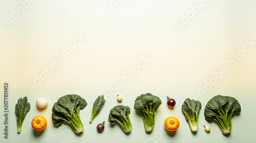 Organic vegetables and fruits arranged in a flat lay on a light background showcasing fresh produce including broccoli, oranges, and eggplants for healthy eating