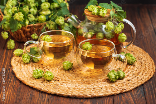Fényképezés Hops herbal tea with fresh cones brewing on rustic table