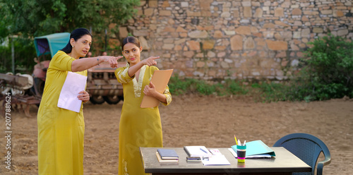 Foto Indian young adult gen z lady female hold files look talk share study learn plan new idea standing rural area