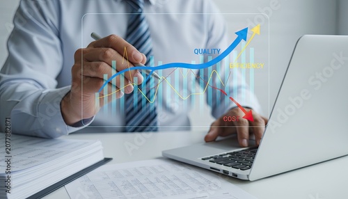Businessman analyzes data, improving quality, efficiency, and reducing costs on a holographic graph.