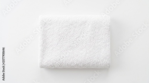 A clean, white folded towel isolated on white background