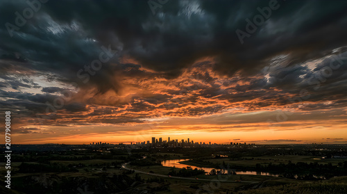 Dramatic cityscape at sunset with dark clouds and vibrant orange sky