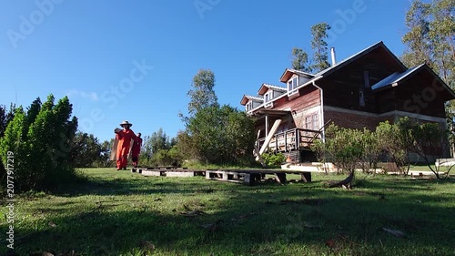 Woman Working in Male Dominated Construction Field Carrying Large Wooden Panel with Male Coworker Near a Rural Property or house on a green landscape: Teamwork and Equality in Blue Collar jobs