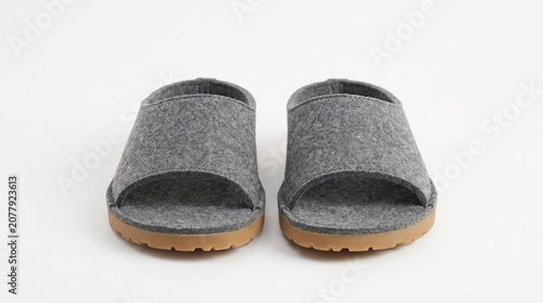 Pair of grey felt slippers with rubber soles isolated on white background
