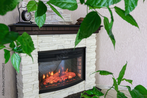 Canvas-taulu modern electric fireplace features a white stone-veneer surround, a dark wooden