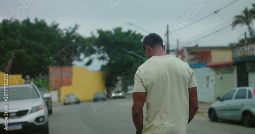 Photography Man of African descent walking away on urban street, back turned to camera, thou