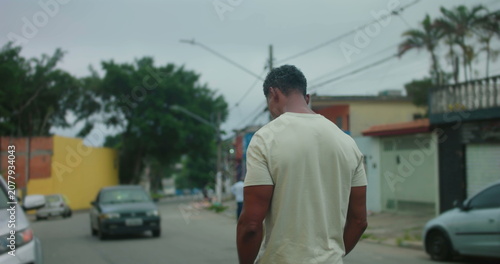 Photography Man of African descent walking away on urban street, back turned to camera, thou