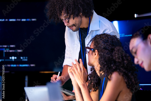 Fotografie Wide shot of a curly-haired developer and a curly-haired engineer explain the di