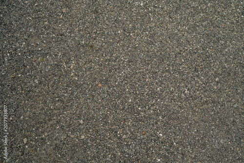 Obraz na plátně Top view full frame abstract background of a rough surface made of tiny gravel stones, pebbles, and sand granules embedded in grey concrete mix, used for architectural paving