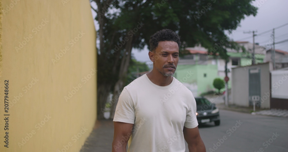 Fototapeta premium Hispanic Afro-Latin man walking forward, playfully scolding someone off-camera, animated expression, friendly neighborhood interaction, casual urban setting