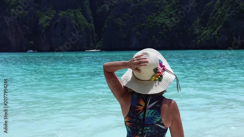 Woman joyfully enjoying the stunningly clear blue waters on a sunny day.