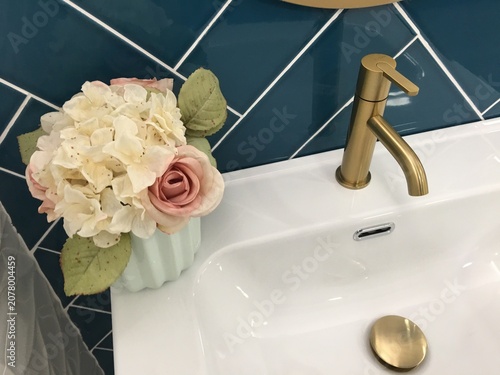 Modern flower decoraded bathroom sink with faucet and blue wall interior design 